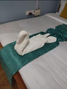 a white towel is laying on a bed at Essie Studios Naivasha CBD in Naivasha +1 photo