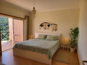 セジンブラにあるMiamar House 6 Sesimbraのベッドルーム1室(ベッド1台付)、スライド式ガラスドアが備わります。