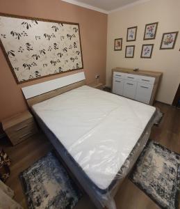 a bedroom with a bed with white sheets on it at Casa & Julieta in Tecuci