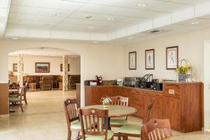 a dining room with a table and a kitchen at Boothill Inn and Suites in Billings