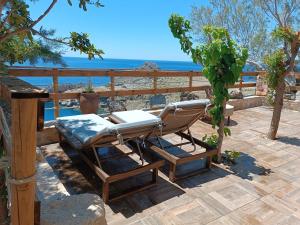 a lounge chair on a deck with the ocean in the background at Vila Apostolis in Agios Pavlos