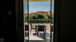 uma mesa e cadeiras numa varanda com uma janela em Italianway - Mimosa 1 int 7 em Cervo