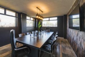 a dining room with a long table and chairs at N1 Hotel Rotten Row Harare in Harare