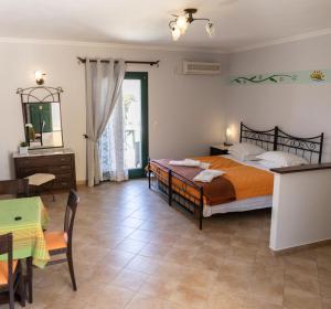 a bedroom with a bed and a dining room with a table at Dilina Studios in Arkasa +14 photos
