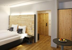 a hotel room with a bed and a table with a bowl of fruit at JUFA Alpenhotel Saalbach in Saalbach Hinterglemm