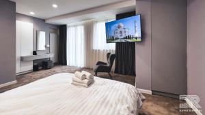 Habitación de hotel con cama y TV de pantalla plana. en DAVID'S RENTAL ROOMs, en Bucarest