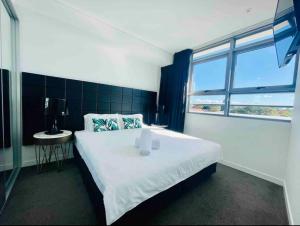 Un dormitorio con una gran cama blanca y una ventana en Chatswood Exeutive Suites - 3beds2baths en Sídney