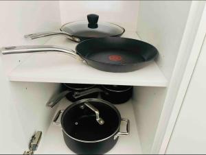 una olla y una sartén en un estante en una cocina en Chatswood Exeutive Suites - 3beds2baths en Sídney