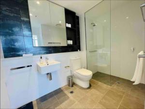 y baño con aseo, lavabo y ducha. en Chatswood Exeutive Suites - 3beds2baths, en Sídney