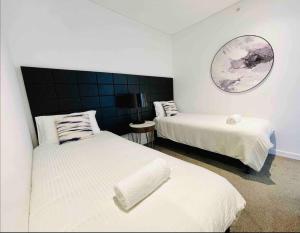 a bedroom with two beds and a mirror on the wall at Chatswood Exeutive Suites - 3beds2baths in Sydney