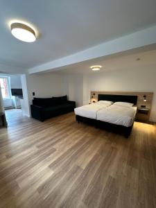 um quarto grande com uma cama e um sofá em Hopfenhotel am Adenauerufer em Bamberg