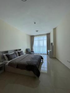 a bedroom with a large bed and a large window at Lovely 2 BHK just 2 min from the beach in Ajman 