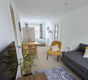 uma sala de estar com um sofá e uma cadeira em Studio Apartment North Cardiff em Cardiff