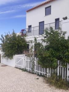 a white house with a white picket fence at ZENergy - GUEST HOUSE in Odeceixe