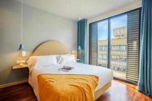 a bedroom with a large bed and a large window at Aspasios Diagonal Art in Barcelona