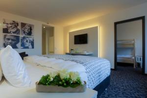 una habitación de hotel con una cama con flores en una mesa en FourSide Hotel Trier, en Trier