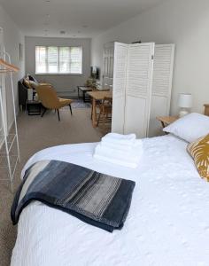 a bedroom with a large white bed and a dining room at Studio Apartment North Cardiff in Cardiff
