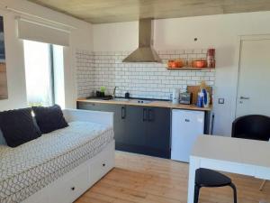 a living room with a couch and a kitchen at ZENergy - GUEST HOUSE in Odeceixe