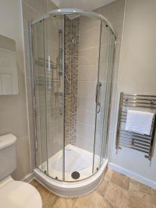 a shower with a glass door in a bathroom at Studio Apartment North Cardiff in Cardiff