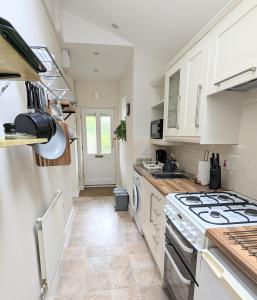 a kitchen with white cabinets and a stove top oven at Studio Apartment North Cardiff in Cardiff