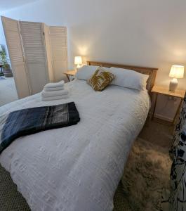 um quarto com uma grande cama branca e 2 candeeiros em Studio Apartment North Cardiff em Cardiff