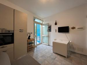 ドンナルカータにあるVeranda sul mare di Donnalucataの壁にテレビ付きのキッチンが備わる客室です。