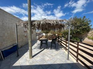 - une terrasse avec une table et un parasol dans l'établissement Veranda sul mare di Donnalucata, à Donnalucata