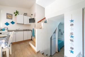 a kitchen and dining room with a staircase in a house at Porto Luna in Villasimius