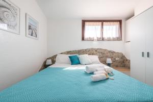 um quarto com uma cama grande e um cobertor azul em Porto Luna em Villasimius