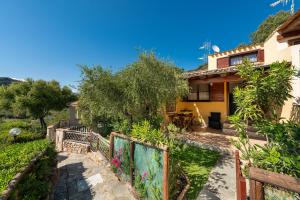 uma casa com um jardim e uma cerca em Porto Luna em Villasimius