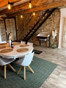 comedor con mesa y piano en Domaine de la Ville Chérel, maison en pierre, en Pontorson