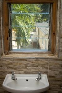 a sink in front of a window with a view at Captains Villa - where Lake Malawi and Shire River meet, historical hotel at waterfront next to the Lake Museum in Mangochi Town in Mponda