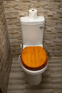 a toilet with a wooden seat in a bathroom at Captains Villa - where Lake Malawi and Shire River meet, historical hotel at waterfront next to the Lake Museum in Mangochi Town in Mponda