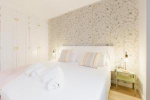 una camera da letto con un grande letto bianco con un muro di Acogedor apartamento en Puerto de la Cruz a Puerto de la Cruz