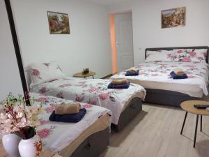 ein Schlafzimmer mit 2 Betten und einem Tisch mit einer Vase in der Unterkunft Castello in Trebinje
