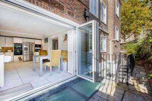 an open patio with a dining room and a kitchen at Londonese House in Chelsea in London