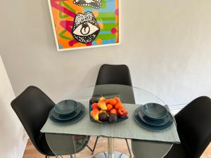 a glass table with black chairs and a plate of fruit at Morden 2 bedroom Apartment tower bridge in London