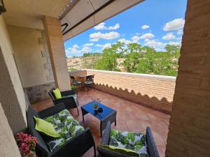 un patio con sedie e un tavolo sul balcone. di Hotel Medina de Toledo a Toledo