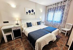 a bedroom with a bed and a desk and a window at Hotel Medina de Toledo in Toledo