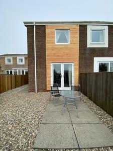a patio with a table and chairs in front of a house at Moonstone in Beadnell