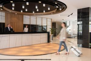 een man die door een lobby loopt met twee mensen die praten bij Bio Suites Hotel & Spa in Rethimnon