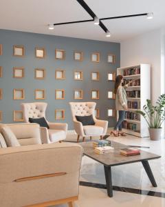 a woman standing in a living room with a book shelf at Bio Suites Hotel & Spa in Rethymno