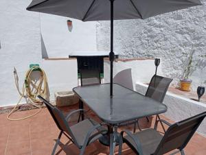 stół i krzesła z parasolem i pianinem w obiekcie The Corner Terraza w mieście Alcaudete