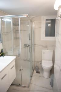 biała łazienka z prysznicem i toaletą w obiekcie Cozy flat 5min to subway station (EPIDAMN) w Atenach