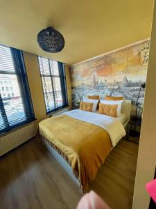 een slaapkamer met een groot bed en een schilderij aan de muur bij The Roosevelt Apartments in Middelburg