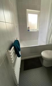 a bathroom with a tub and a toilet and a window at Moonstone in Beadnell