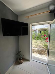 Studio apartman Bačvice في سبليت: غرفة بها نافذة وتلفزيون بشاشة مسطحة