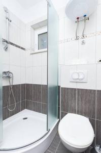 Un baño con inodoro y ducha de cristal. en Studio apartman Bačvice, en Split