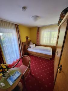 a bedroom with a bed and a table and a chair at Gästehaus Schwarz in Prien am Chiemsee