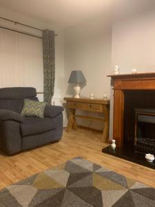 sala de estar con sofá y chimenea en Beautiful 2-Bed House in Larne with free parking en Larne